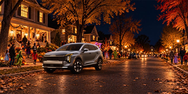 A Kia Sportage parked on a suburban street decorated for Halloween.